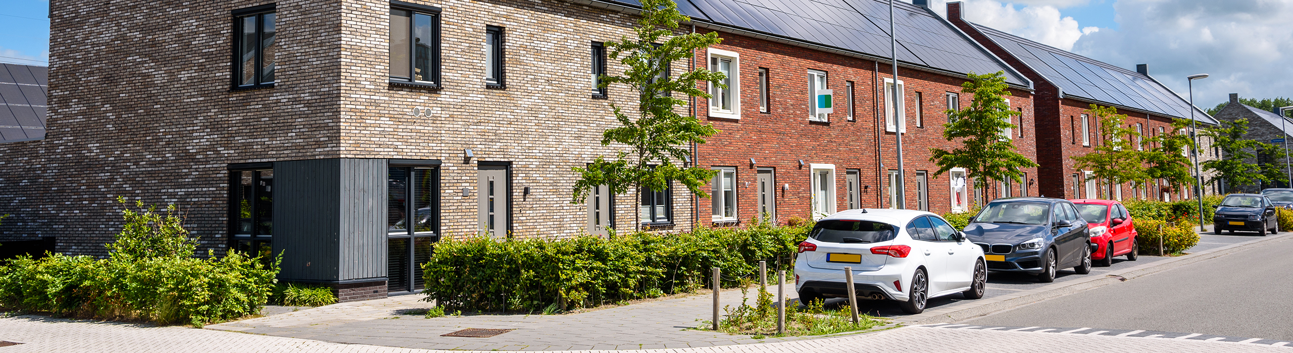 Row of new energy efficient brick terraced houses with the rooftop covered with solar panels on a sunny summer day. Groningen, Netherlands.